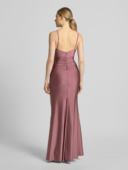 Frauenmodel trägt Abendkleid mit seitlichem Gehschlitz und Wasserfall-Ausschnitt von Mascara aus Satin in Altrosa, Maxikleid, Rückenansicht. Körpernaher-Schnitt, Spaghettiträger, Rückseite mit Haken- und Reißverschluss, Rückenlänge 125 cm, Brustweite 40 cm.