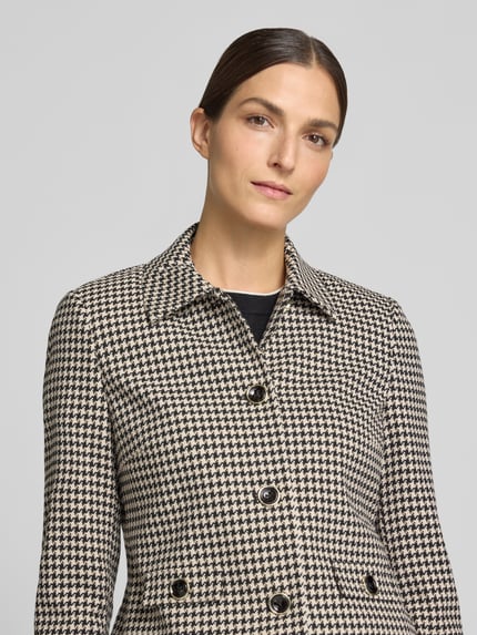 Kobiece model nosi Slim Fit Blazer mit Hahnentrittmuster von Christian Berg Woman Selection, Mieszanka materiałów z dodatkiem wiskozy, krój slim fit, Pepitka, wykładany kołnierz, listwa guzikowa, długość tyłu w rozmiarze 36: 50 cm, szerokość w rozmiarze 36: 43 cm, długość rękawów w rozmiarze 36: 62 cm, zbliżenie na górną część ciała.
