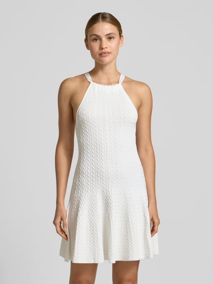 Frauenmodel trägt Tailliertes Strickkleid aus Viskose-Mix von Polo Ralph Lauren in Weiß mit Zopfmuster, Strickoptik und Collierkragen, Nahaufnahme Oberkörper.