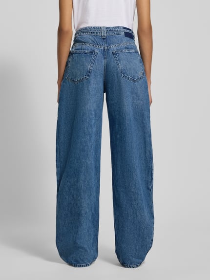 Kobiece modelka nosi Wide Leg Jeans aus Baumwoll-Lyocell-Mix Modell 'C_PLEATED BARREL 1.0' od BOSS Orange, stylizowana na denim, krój wide fit, naszywka z logo, nity, zakładka w pasie, szlufki na pasek, zapięcie na guzik i ukryty zamek błyskawiczny, wiązany pasek, wpuszczane kieszenie, kieszenie z tyłu, mieszanka bawełny i lyocellu, widok całej sylwetki z tyłu.