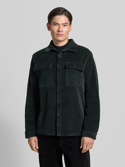 Männermodel trägt Regular Fit Overshirt mit Pattentaschen Modell 'Taylor' von Zuitable, Baumwoll-Mix, dunkelgrün, Ganzkörperansicht von vorne.
