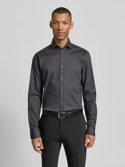 Männermodel trägt Regular Fit Businesshemd mit extralangem Arm Modell 'H-JOE-SPREAD' von BOSS, unifarben, Kentkragen, Ganzkörperansicht von vorne.