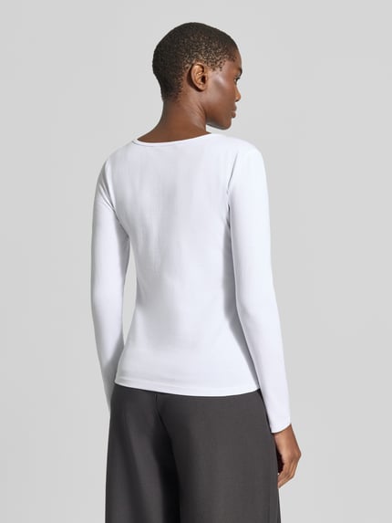 Vrouwenmodel draagt shirt met lange mouwen uit mix van katoen en elastaan, getailleerd model, ronde hals, ruglengte maat S 57 cm, Longsleeve uit katoenmix van ZABAIONE. Ganzkörperansicht Rückansicht.