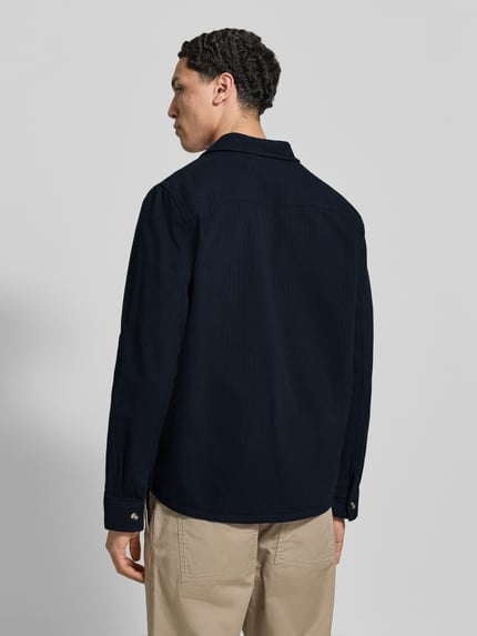 Männermodel trägt Regular Fit Hemdjacke mit Brusttaschen Modell 'DENNY' von Blend in Dunkelblau, reine Baumwolle, Rückansicht, Ganzkörperansicht.