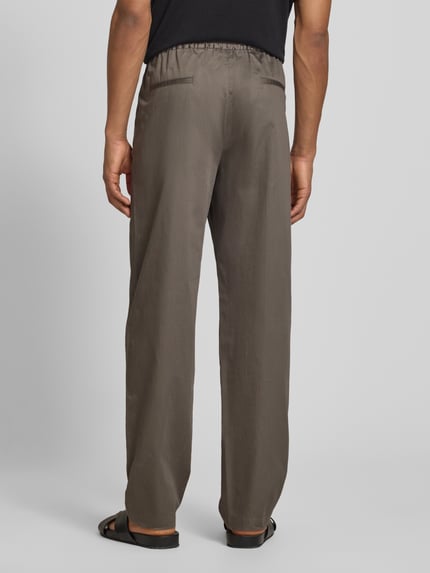 Männermodel trägt Hose mit elastischem Bund und Gesäßtaschen von Emporio Armani in Braun, Material-Mix, Ganzkörperansicht Rückansicht.
