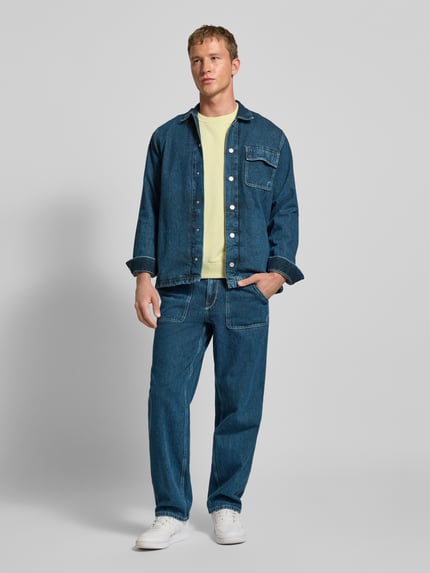 Männermodel trägt Regular Fit Jeansjacke aus reiner Baumwolle Modell 'OTTO' von Pepe Jeans in Melange-Optik, Denim, Ganzkörperansicht von vorne.