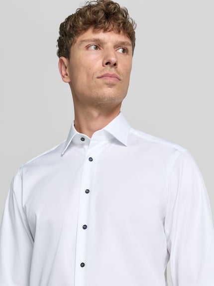 Männermodel trägt Extralanges Regular Fit Business-Hemd mit Kentkragen von Christian Berg Men, Unifarbenes-Design, Reine Baumwolle, Nahaufnahme Oberkörper.