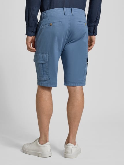 Männermodel trägt Bermudas mit Cargotaschen von bugatti in Blau, Regular-Fit, Cargotasche, Gesäßtasche, Knopfverschluss, Ganzkörperansicht Rückansicht. Bundweite 45 cm, Innenbeinlänge 30 cm bei Größe 50.