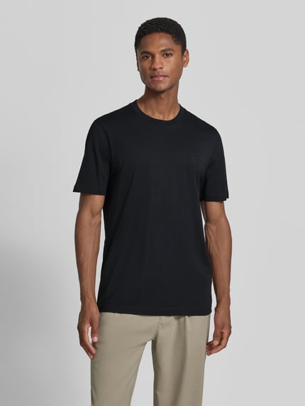 Męski model nosi Regular Fit T-Shirt mit Logo-Stitching od MCNEAL z bawełny, okrągły dekolt, czarny, długość tyłu 70 cm w rozmiarze M, Ganzkörperansicht von vorne