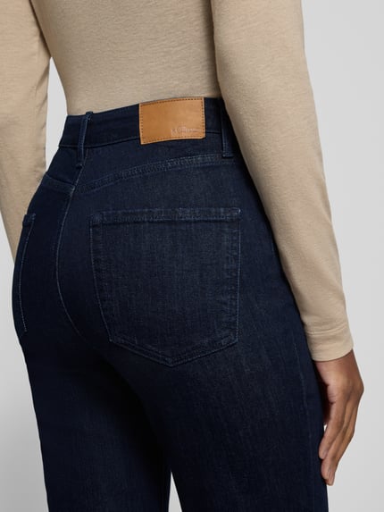 Frauenmodel trägt Regular Fit Bootcut Jeans mit Teilungsnähten von S.OLIVER CASUAL in Dark Wash Denim mit sichtbaren Nähten und 5-Pocket-Design, Nahaufnahme Rückansicht.