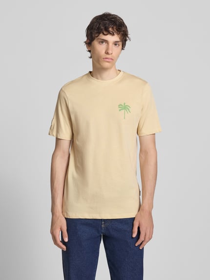 Männermodel trägt T-Shirt mit Motiv-Print Modell 'SUN PALMS' von Blend in Beige, Rundhalsausschnitt, reine Baumwolle, Ganzkörperansicht von vorne.
