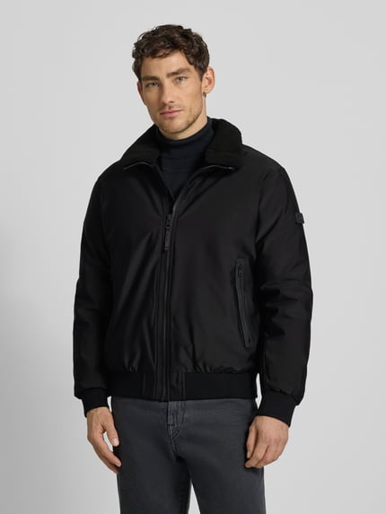 Männermodel trägt Bomberjacke mit Stehkragen Modell 'Ginster' von khujo in Schwarz, Material-Mix, Regular Fit, Nahaufnahme Oberkörper.