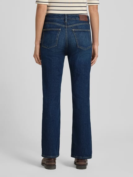 Frauenmodel trägt Straight Fit Jeans mit Eingrifftaschen Modell 'DEAVIE' von Lauren Ralph Lauren aus Baumwoll-Elasthan-Mix, dunkle Bluejeans, Bundweite 39 cm, Innenbeinlänge 72 cm, klare Struktur, dezente Nähte, Ganzkörperansicht Rückansicht.