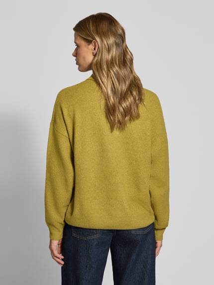 Frauenmodel trägt Oversized Strickpullover mit Polokragen von REVIEW in Gelbton, lockerer Schnitt, Material-Mix mit Stretch-Anteil, Ganzkörperansicht Rückansicht.