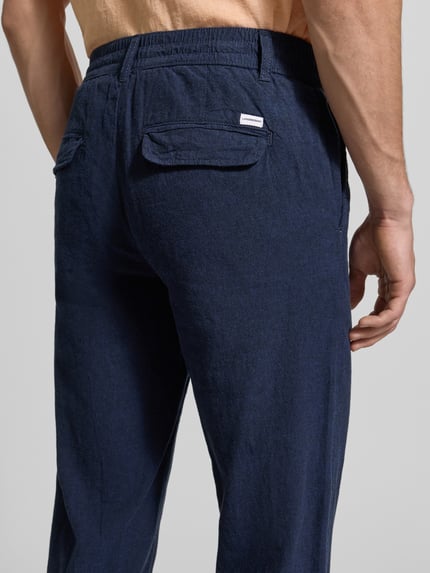 Männermodel trägt Hose aus Leinen-Baumwoll-Mix mit elastischem Bund von Lindbergh, dunkelblau, Regular-Fit, Ganzkörperansicht Rückansicht, Eingrifftaschen, Bundweite 40 cm, Innenbeinlänge 79 cm.