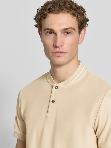 Männermodel trägt Regular Fit Poloshirt aus einer Baumwolle C-PRATT40 von BOSS, Optik: Unifarben, Label-Stitching-Applikation, V-Ausschnitt, kurze Knopfleiste, Ärmelform: Kurzarm, Ärmelabschluss: Gerippt, Materialverarbeitung: Piqué, Material: Reine Baumwolle, Nahaufnahme Oberkörper.