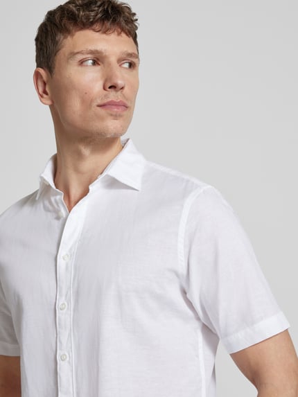 Männermodel trägt weißes Slim Fit Freizeithemd aus Leinen-Mix von Jake*s mit Kentkragen, Nahaufnahme Oberkörper, Baumwoll-Anteil.
