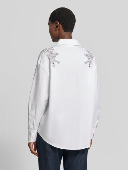 Vrouwenmodel draagt Bluse mit Spitze und Hemdblusenkragen Modell 'SHIRLEY' van Cph Muse, puur katoen, regular fit, witte kleur, knoopsluiting, sportmanchet, afgeronde zoom, kantdetails op schouders, ruglengte maat S 73 cm, mouwlengte maat S 45 cm, geheel achteraanzicht.
