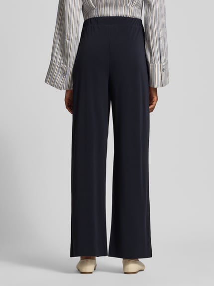 Frauenmodel trägt Relaxed Fit Stoffhose mit Tunnelzug von MM by Max Mara in Dunkelblau, lockere Form, glatte Textur, Ganzkörperansicht Rückansicht. Damen Stoffhose mit Gürtelschlaufen und Eingrifftaschen, Bundweite S: 34 cm, Innenbeinlänge S: 78 cm.