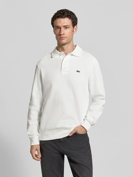 Männermodel trägt Regular Fit Sweatshirt aus reiner Baumwolle von Lacoste in Weiß, strukturierte Oberfläche, Ganzkörperansicht von vorne. Herren Sweatshirt von Lacoste