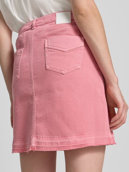 Frauenmodel trägt Straight Fit Minirock in Denim-Optik von Marc Cain, Baumwoll-Mix, rosa, sichtbare Eingriff- und Gesäßtaschen, Knopf- und Reißverschluss, Ganzkörperansicht Rückansicht.