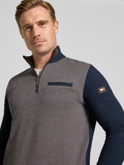 Männermodel trägt Sweatshirt mit Label-Details von bugatti in Blau und Grau mit Brusttasche, Nahaufnahme Oberkörper, elastischer Material-Mix.