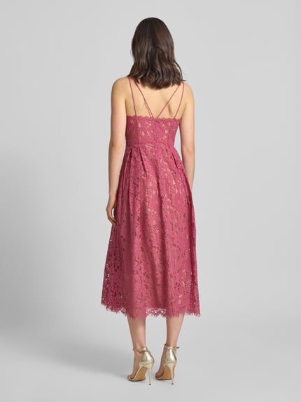 Frauenmodel trägt Knielanges Cocktailkleid mit Spitze und Spaghettiträgern von Jake*s Cocktail, Baumwoll-Mix, taillierter Schnitt, Knielänge, doppelte Spaghettiträger, V-Ausschnitt, Rückseite mit Haken- und Reißverschluss, Unterkleid, Spitzenstruktur in Rosé, Ganzkörperansicht Rückansicht.