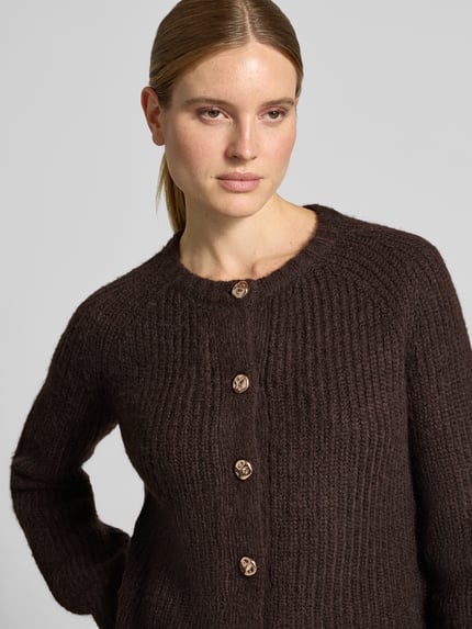 Frauenmodel trägt Regular Fit Cardigan in Strick-Optik von Christian Berg Woman Selection, braun, grobe Textur, Nahaufnahme Oberkörper.