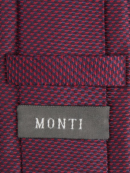 Produktfoto, Krawatte aus reiner Seide von Monti in Dunkelrot mit blauen Akzenten, klassische Passform, Label-Detail, strukturierte Textur.
