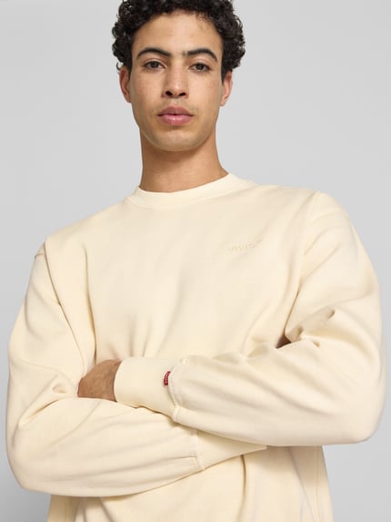 Männermodel trägt Relaxed Fit Sweatshirt aus reiner Baumwolle von Levi's®, unifarben, Rundhals, langarm, Nahaufnahme Oberkörper.