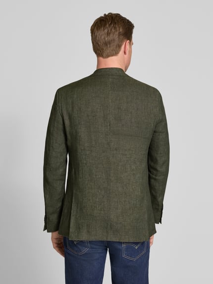 Männermodel trägt Sakko aus Viskose mit Einstecktuch Modell 'Tebbo' von Carl Gross in Olive, feine Struktur, Rückenansicht, Ganzkörperansicht Rückansicht. Regular Fit, Reverskragen, Knopfverschluss, Brustleistentasche, Rückenlänge 75 cm, Schulterbreite 48 cm, Ärmellänge 65 cm.