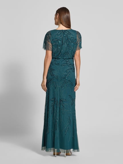 Frauenmodel trägt Abendkleid mit Perlen und Pailletten von Christian Berg Cocktail, taillierter Schnitt, Maxikleid in Petrol, Ganzkörperansicht Rückansicht.