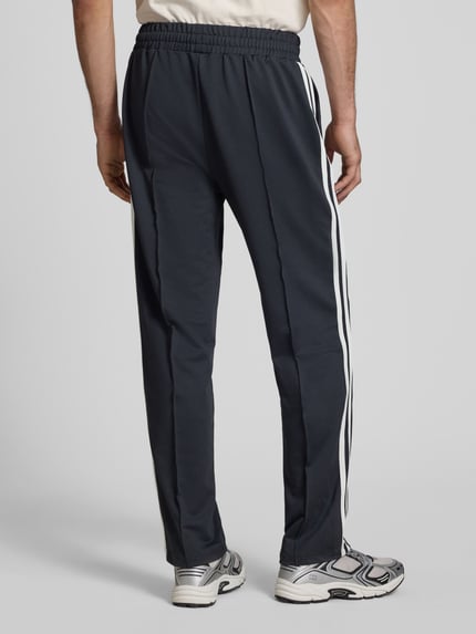 Mannelijk model draagt donkergrijze straight fit sweatpants met logodetail, elastische materiaalmix, model 'Latucci' van Ellesse, ganzebovenaanzicht rugaanzicht.