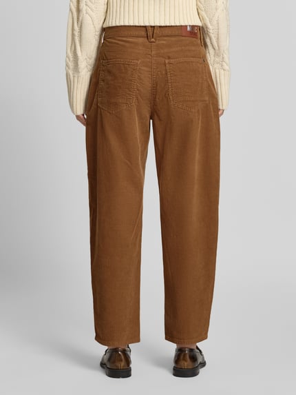 Frauenmodel trägt Regular Fit Cordhose aus Baumwoll-Mix Modell 'DANNI 2.3' von MAC in Braun, grobe Cordstruktur und sichtbare Taschen, Ganzkörperansicht Rückansicht, Damen Cordhose von MAC.
