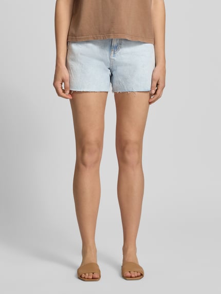 Kobiece model nosi Regular Fit Jeansshorts aus reiner Baumwolle Modell 'RACHEL' od Pepe Jeans, stylizowana na denim, krój regular fit, wysoki stan, naszywka z logo, szlufki na pasek, zapięcie na guzik i ukryty zamek błyskawiczny, zakończenie nogawek: frędzle, 5 kieszeni, bawełna, jasnoniebieski, gładka tekstura, widok całej sylwetki z przodu.