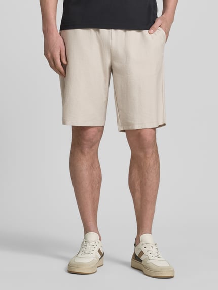 Männermodel trägt Bermudas mit Strukturmuster und elastischem Bund von Fynch-Hatton aus Reine Baumwolle in Regular-Fit, Nahaufnahme Oberschenkel.