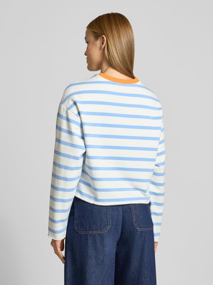 Frauenmodel trägt Sweatshirt mit Logo-Patch und Rollsaum von Smith and Soul aus Baumwoll-Mix mit Modal-Anteil, gestreift in Blau und Weiß, Boxy-Fit, gerippter Rundhalsausschnitt, Rollsaum, Ganzkörperansicht Rückansicht.