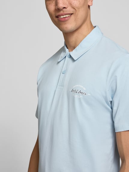 Męski model nosi Poloshirt mit Label-Print Modell 'BRANDON' od Jack & Jones, bawełna, krój regular fit, krótka listwa guzikowa, kolor jasnoniebieski, polo, nadruk z logo, długość tyłu w rozmiarze M: 71 cm, zbliżenie na górną część ciała.