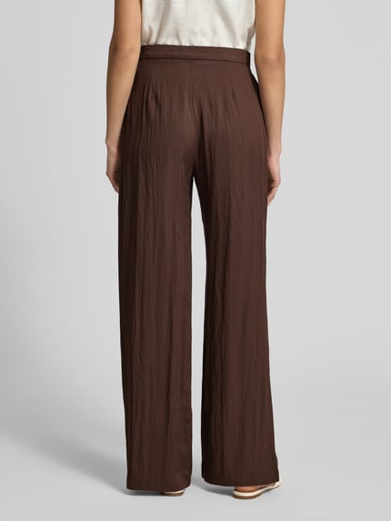 Frauenmodel trägt Stoffhose aus Lyocell-Mix mit Schnürung von Jake*s Casual in Dunkelbraun, Wide Leg, stofftypisch strukturierte Textur, Ganzkörperansicht Rückansicht.