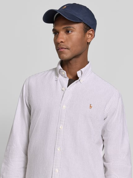 Männermodel trägt Regular Fit Freizeithemd aus reiner Baumwolle von Polo Ralph Lauren, feine Streifen in Weiß und Hellgrau, Nahaufnahme Oberkörper.