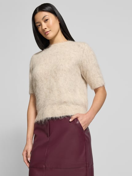 Vrouwenmodel draagt Midirock met Franse steekzakken model 'DAGMAR' van Vila, rechte snit, leren look, nahaufnahme bovenlichaam.