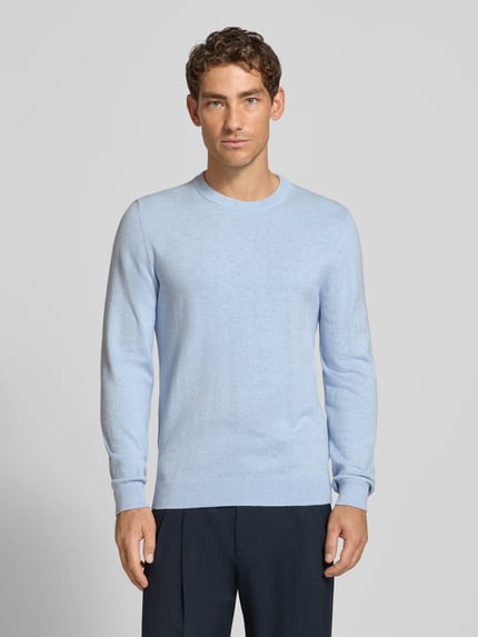 Männermodel trägt Strickpullover aus Baumwoll-Kaschmir-Mix mit Rundhalsausschnitt von MCNEAL, hellblau, Regular Fit, Ganzkörperansicht von vorne. Rückenlänge bei Größe M: 70 cm, Ärmellänge 74 cm.