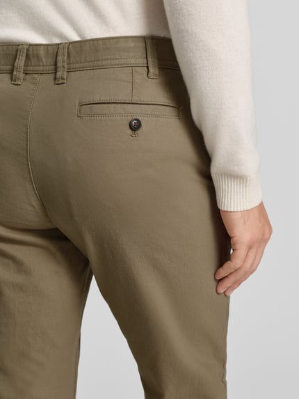 Mannelijk model draagt Stoffhose mit Gesäßtaschen van MCNEAL in olijfgroen, katoenmix met steek- en achterzak, detailopname rug.