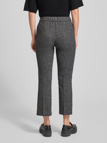 Frauenmodel trägt Slim Fit Stoffhose mit Viskose-Anteil Modell 'Jenny' von TONI in Anthrazit mit Bügelfalten, elastischem Bund, Paspeltaschen, Ganzkörperansicht Rückansicht.