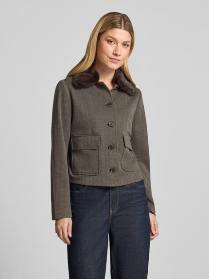 Frauenmodel trägt Webpelzjacke mit kontrastierendem Kragen von zero, Melange-Optik, Fischgrätenmuster, Pattentaschen, Ganzkörperansicht von vorne.
