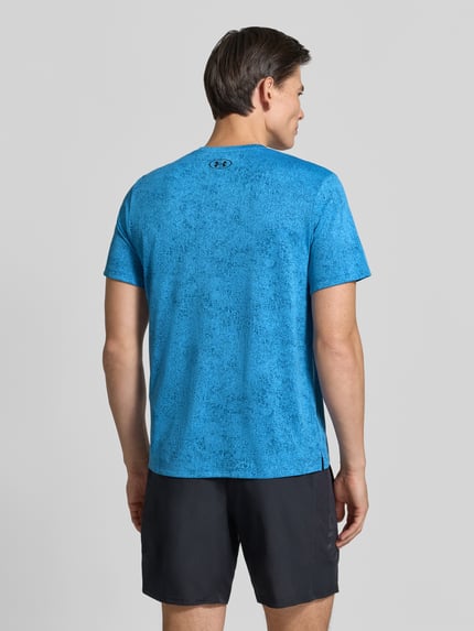 Männermodel trägt Regular Fit Sport-T-Shirt mit Strukturmuster Modell 'Pixelate' von Under Armour in Blau und Schwarz, Ganzkörperansicht Rückansicht.