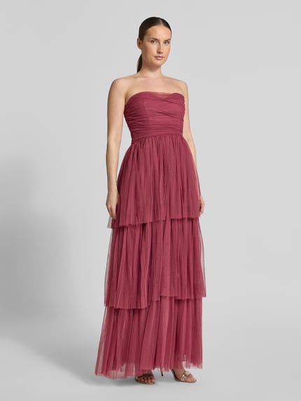 Frauenmodel trägt Regular Fit Abendkleid mit Rüschenbesatz von LACE & BEADS aus Mesh in A-Linie, schulterfrei und tailliert, Ganzkörperansicht von vorne.