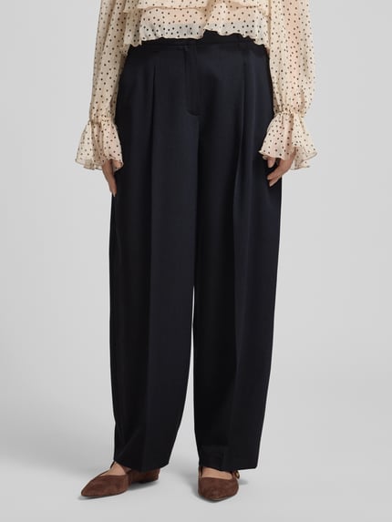 Frauenmodel trägt Barrel Fit Hose Modell 'Moira Bloom' von OPUS PANTS, schwarz, Baumwoll-Mix mit Bügelfalten, Nahaufnahme Vorderansicht.