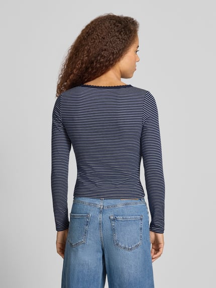 Frauenmodel trägt T-Shirt mit Rippstrickstruktur von LEVIS 300 mit Allover-Streifenmuster in Dunkelblau, Cropped-Länge, Ganzkörperansicht Rückansicht.