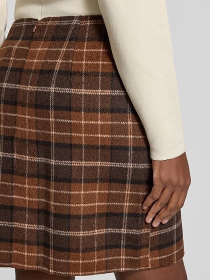 Frauenmodel trägt Rock mit formgebenden Nähten von S.OLIVER CASUAL im mehrfarbigen karierten Wollmix-Design, Mini-Länge, Nahaufnahme Hüfte.